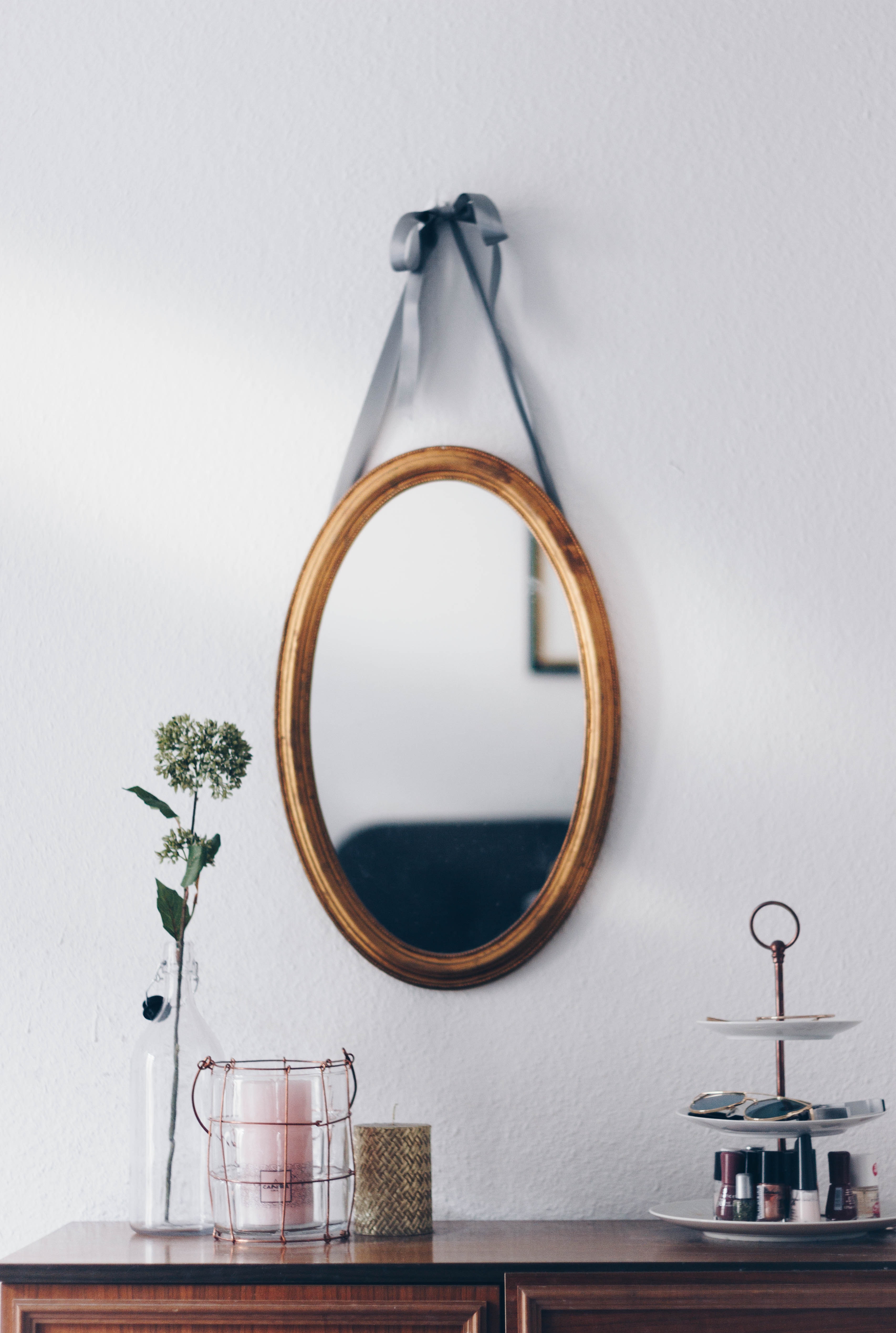 oval mirror hanging on a wall