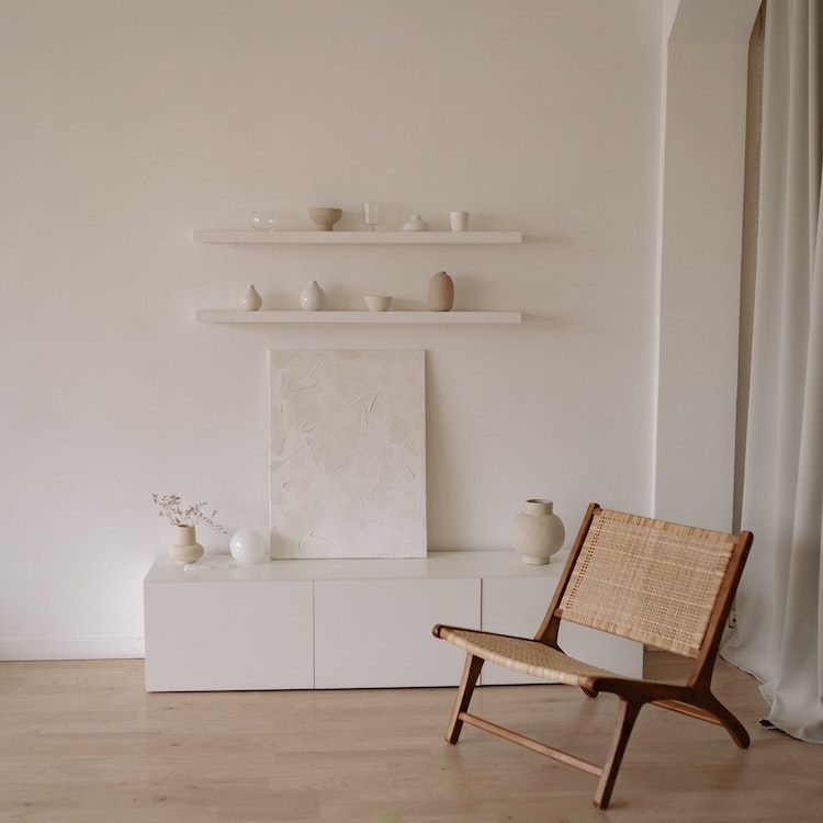 White shelves and countertop holding vases and a brown bench